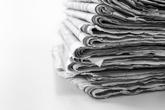 Newspapers folded and stacked concept for global communications and the media